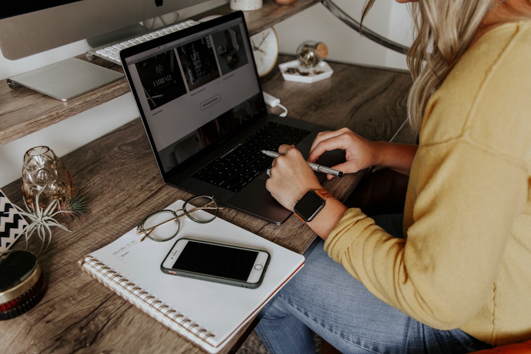 Ilustrasi: Person in blue denim jeans using macbook pro