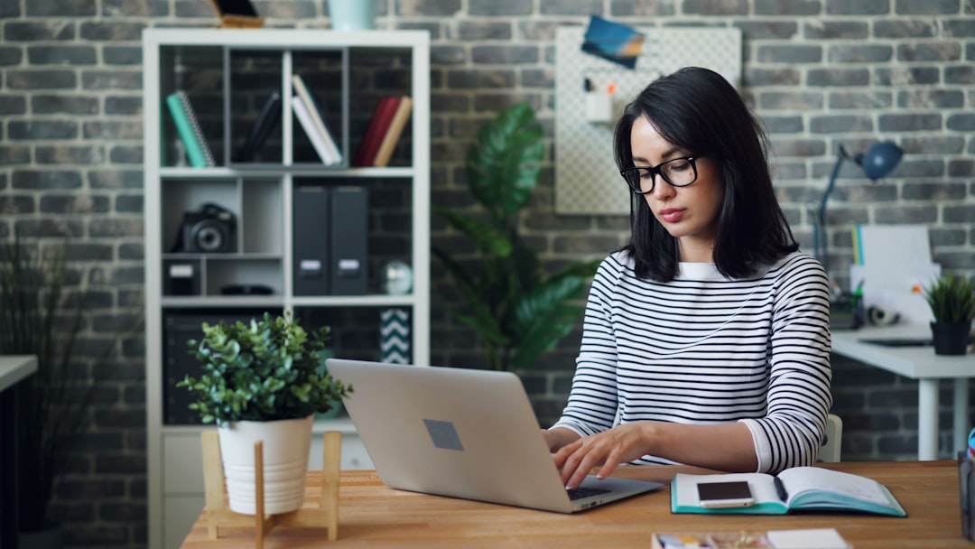 Ilustrasi: A woman sitting at a desk using a laptop computer