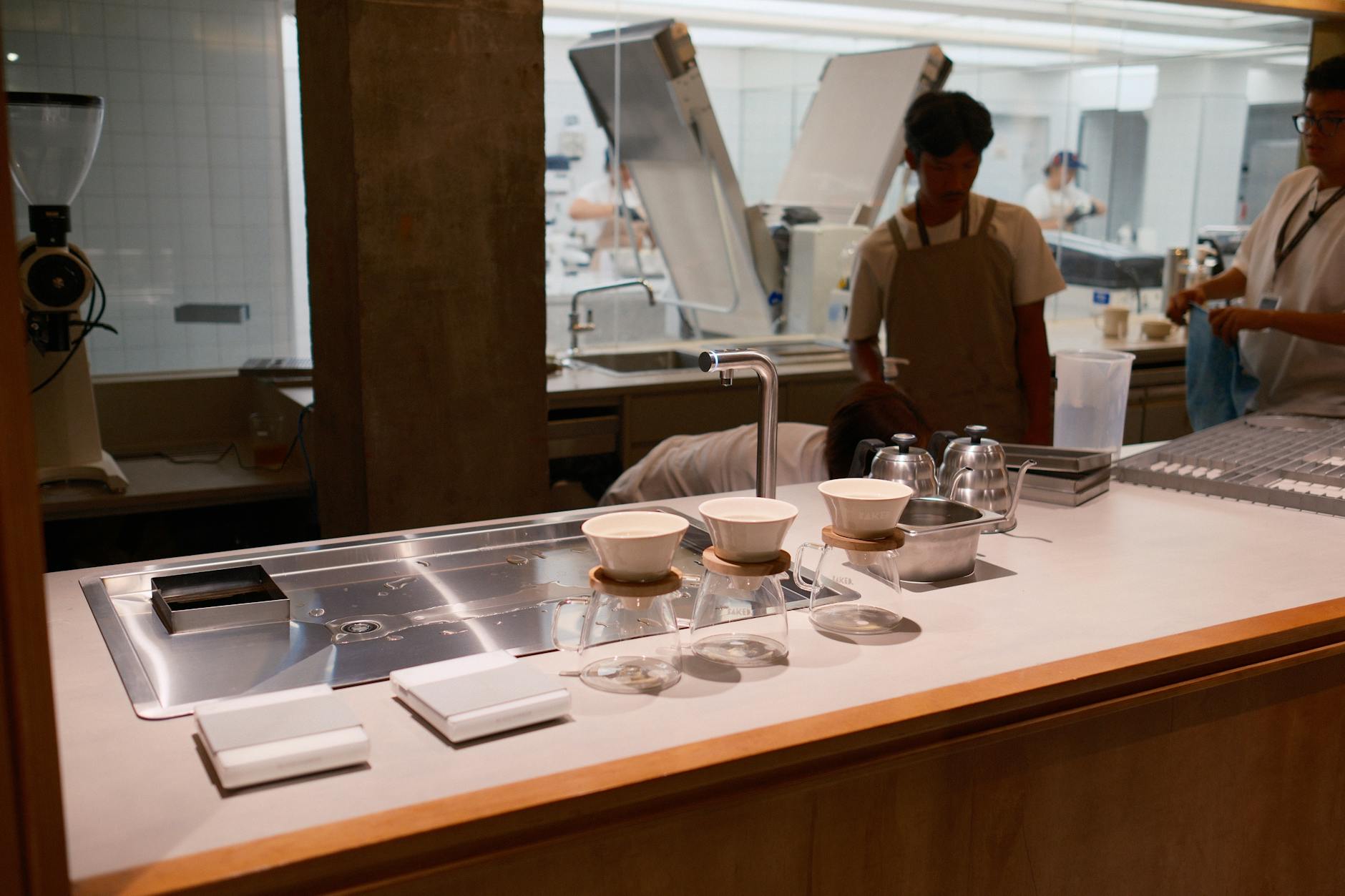 Ilustrasi: A sleek coffee brewing station with baristas in a modern Jakarta café. Perfect for café and coffee-themed presentations.