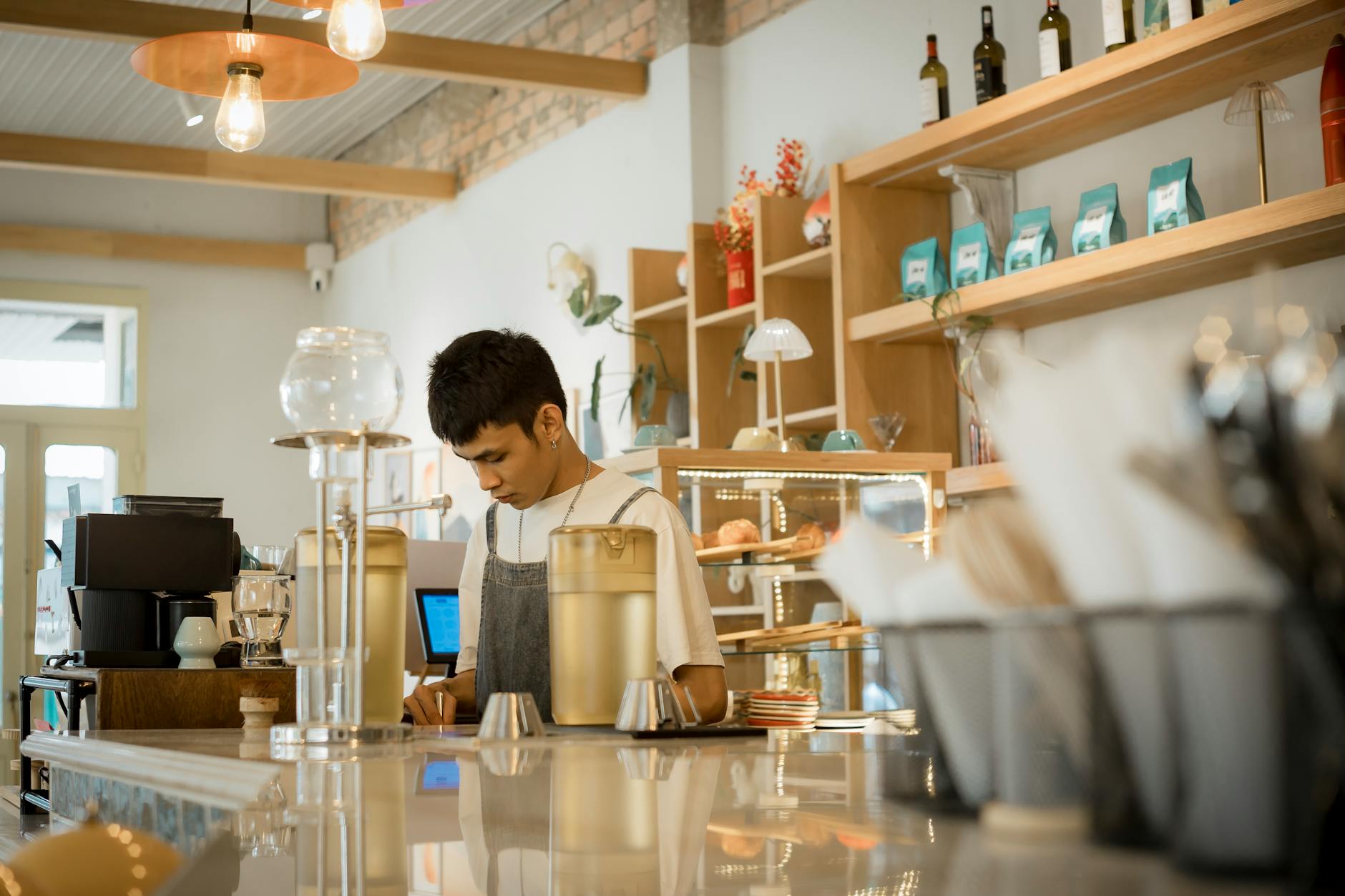 Ilustrasi: Young barista working in a stylish cafe preparing coffee drinks. Urban lifestyle setting.
