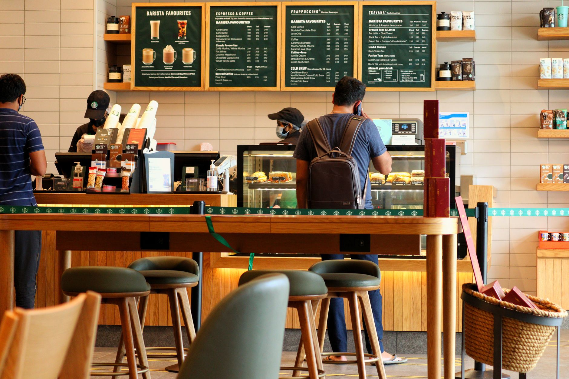 Ilustrasi: Customers at a bustling coffee shop counter ordering drinks and pastries.