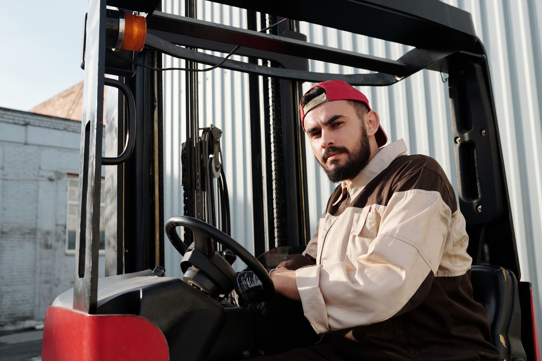 Ilustrasi: Forklift operator confidently working in an industrial outdoor environment, showcasing focus and skill.