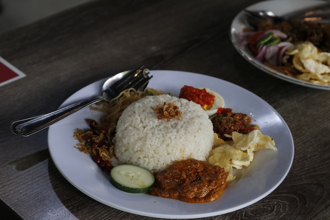 Ilustrasi: A white plate topped with rice and meat