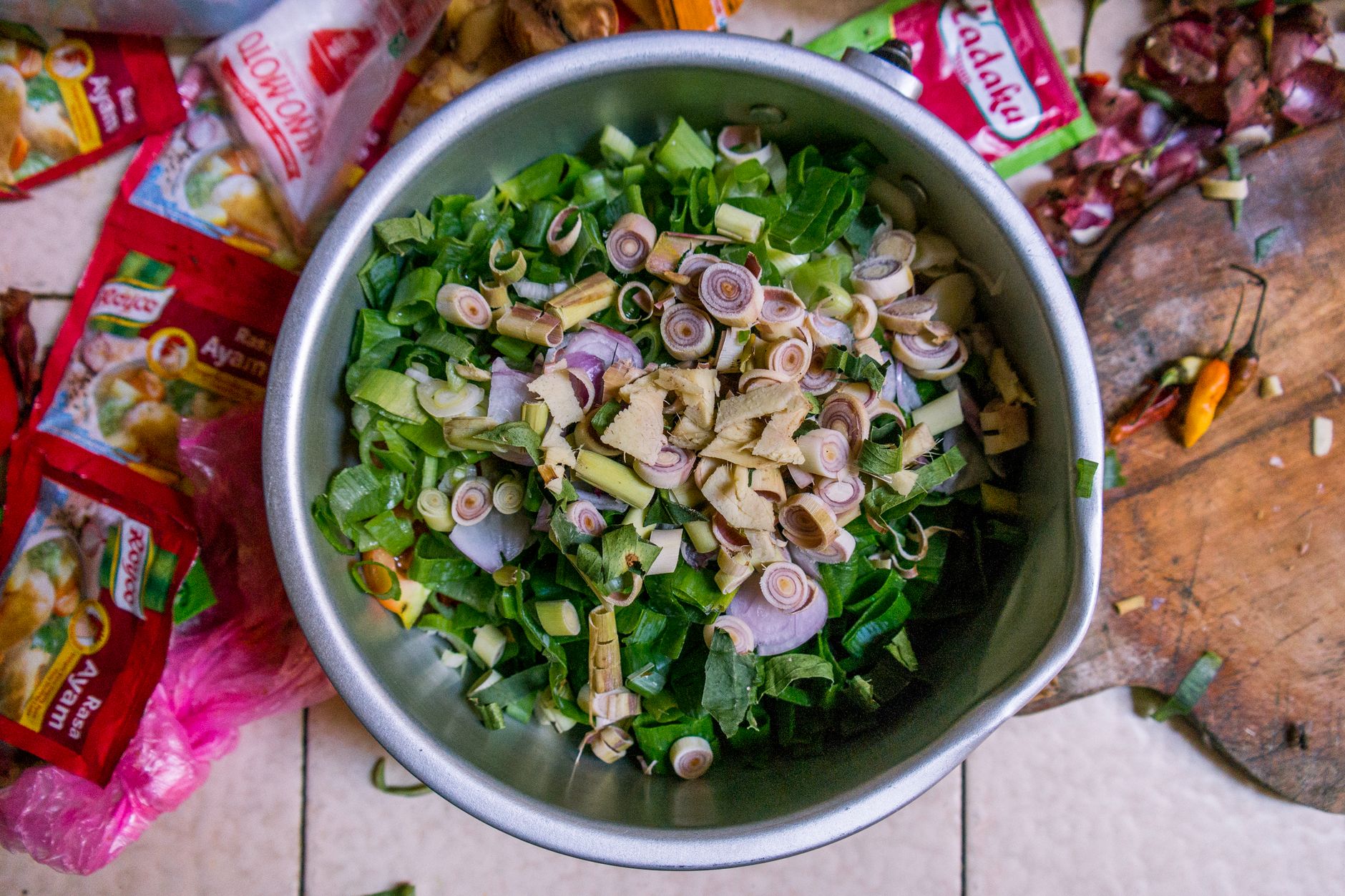 Ilustrasi: A top view of fresh ingredients like lemongrass and shallots in a bowl, ready for Indonesian cooking.