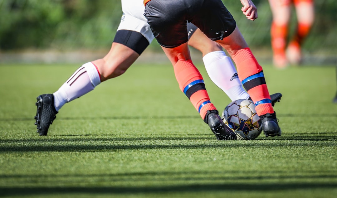 Ilustrasi: Woman in black and white sepak bola jersey kicking sepak bola ball on green lapangan during daytime